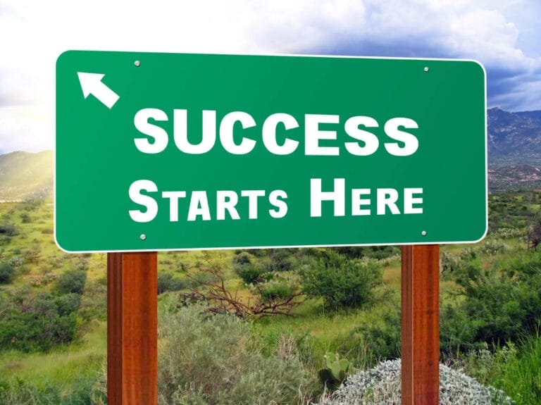 A sign board with the words "Success Starts Here" displayed prominently, placed on an open door