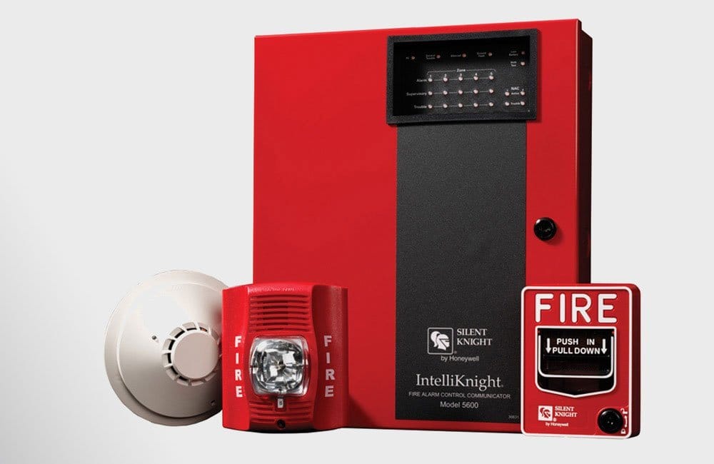 A fire alarm system with a red box and a white button.