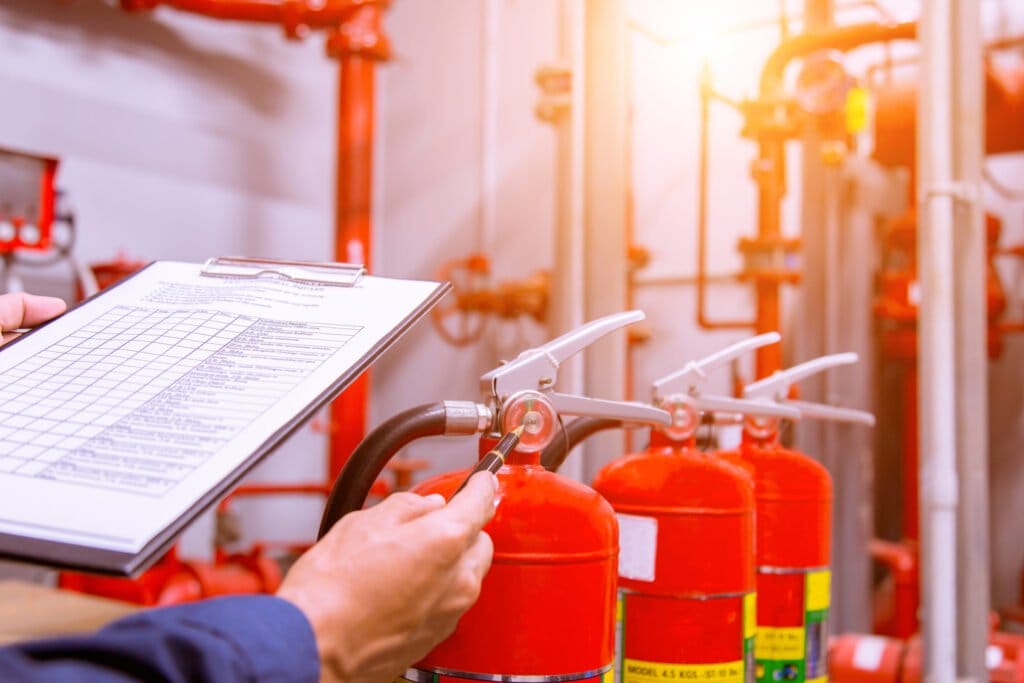 The image shows several red fire extinguishers mounted on a wall.