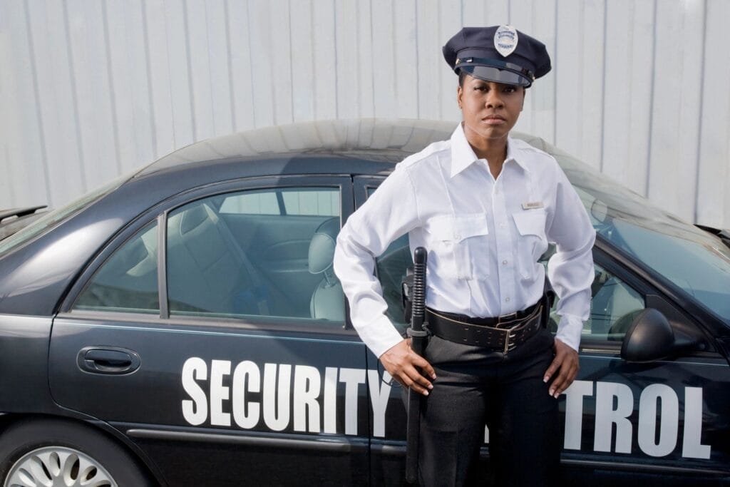 A security woman standing besides the security protocal black color car